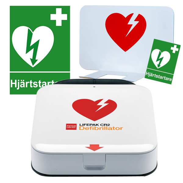 Hjärtstartarpaket med olika tillbehör. En grön skylt med ett vitt hjärta, ett vitt väggfäste med rött hjärta och vit hjärtstartare lifepak cr2. 