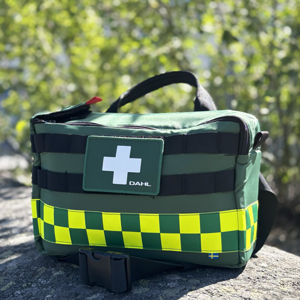 En grön första hjälpen-kit med ett vitt kors på en grön bakgrund, märkning 