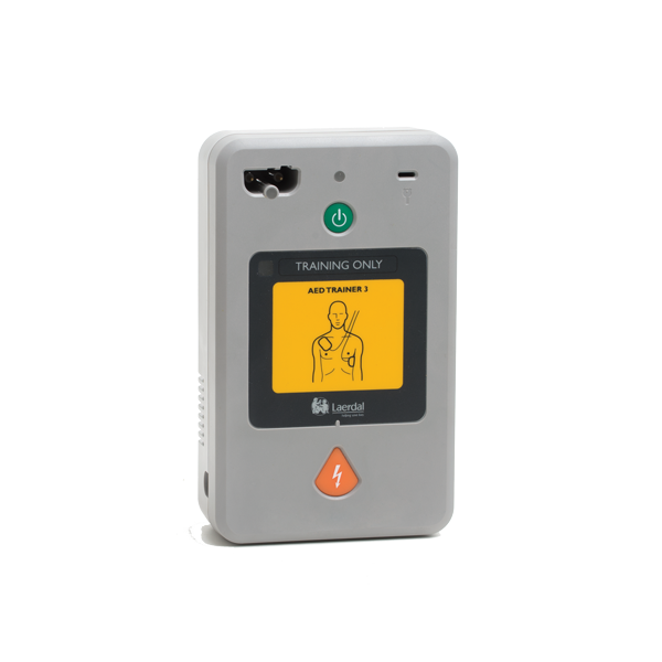 Övningshjärtstartare AED, i en liten grå design med grön knapp för på och en orange för ström. På är det en gul bild som visar på en sträckgubbe hur elektroderna ska placeras. 